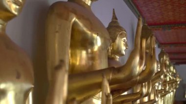 Wat Pho Tapınağı, Tayland 'da abhaya jesti yapan altın bir sıra Buda heykelinin izini sürüyorum.