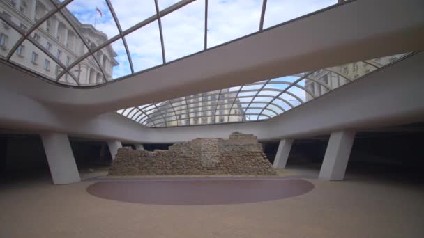 Rastreando lejos de una pared romana arruinada en el área de exhibición subterránea de la Plaza Serdica en Sofía, Bulgaria — Vídeos de Stock