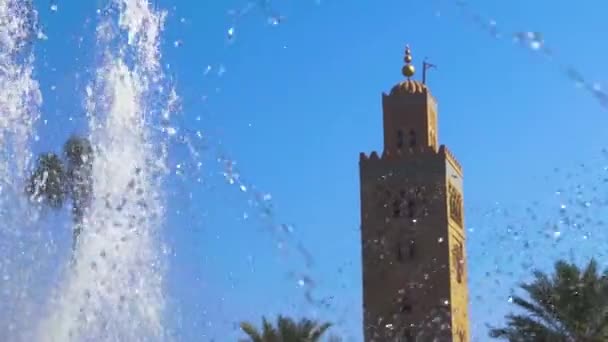 Gotas de agua de una fuente que enmarca el minarete de la mezquita de Koutoubia, Marrakech, Marruecos — Vídeos de Stock