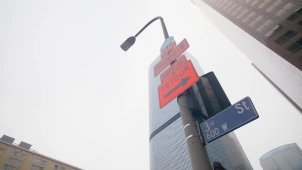 Looking up at a lamp post in LA with signs on it — Stock Video