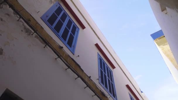 Blick nach oben zwischen Gebäuden entlang einer schmalen Straße in Essaouira, Marokko — Stockvideo