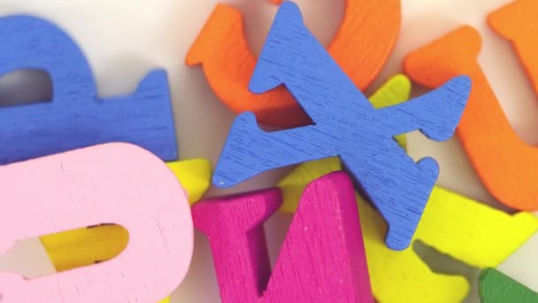 Rotating macro shot of colourful wooden letters of the alphabet — Stock Video