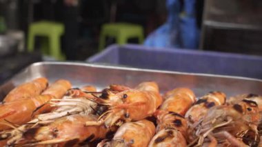 Çin Mahallesi, Bangkok 'taki bir lokantada ızgara karides tepsisi üzerinde iz sürüyorum.