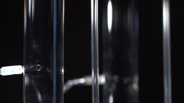 Légbuborékok, amelyek üvegcsőből tartályba vándorolnak — Stock videók