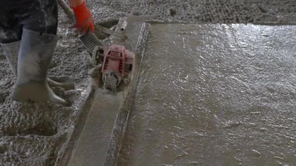 Builder levelling a concrete floor using a bull float on a building site — Stock Video