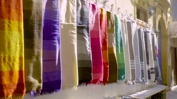 Färgglada halsdukar hängande från en vägg i Essaouira, Marocko — Stockvideo