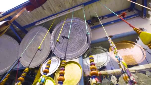 Handheld shot panning down jewellery and beads on display outside a shop in Morocco — Stock Video