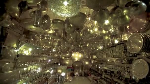 Handheld shot tracking into a shop in Marrakesh selling silver lamps and other objects — Stock Video