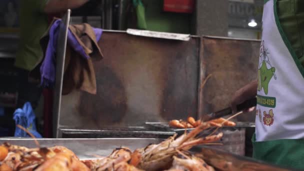 Продавец уличной еды готовит креветки на гриле в киоске в Чайнатауне, Бангкок — стоковое видео
