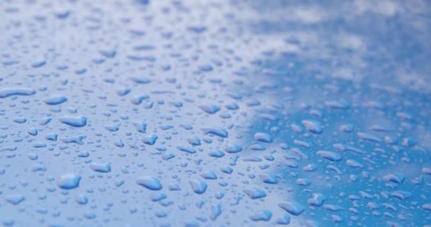 Gotas de lluvia en un capó de coche azul — Vídeo de stock
