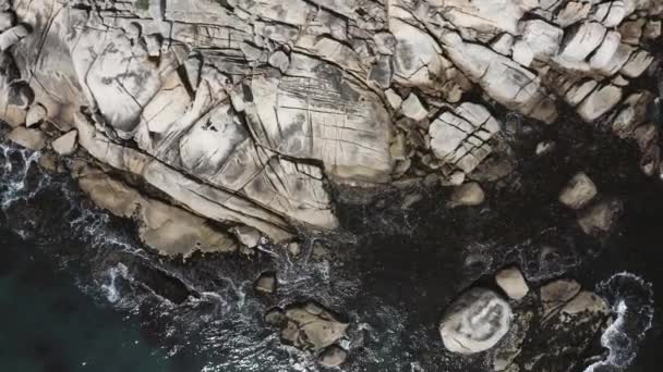 Obracający się strzał z powietrza spadający nad skałami przybrzeżnymi — Wideo stockowe