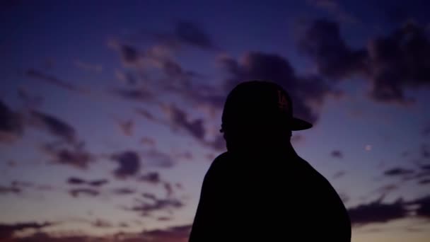 Venice Beach Kaykay Parkı, Los Angeles 'ta gün batımında beyzbol şapkalı bir adamın silueti. — Stok video