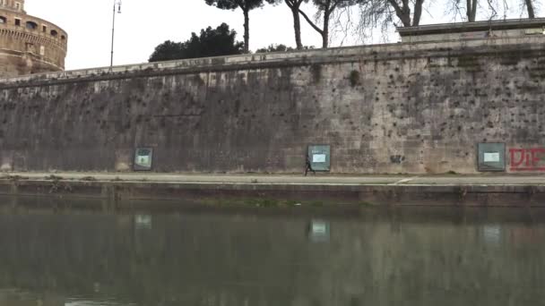 En person som springer längs floden Tibern i Rom — Stockvideo