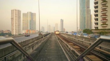 Skytrain ve arabalar Bangkok, Tayland 'da köprüden geçiyor.