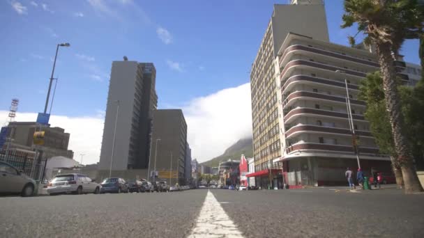 En bil kör ner Roeland Street i Kapstaden och sedan svänger det höger, till en annan gata — Stockvideo