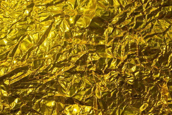 Gold leaf background texture with shiny crumpled uneven surface