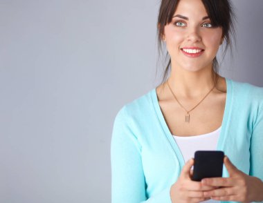 Akıllı telefon kullanan ve okuyan bir kadın