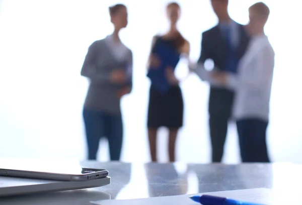 Laptop auf dem Schreibtisch, Geschäftsleute im Hintergrund — Stockfoto