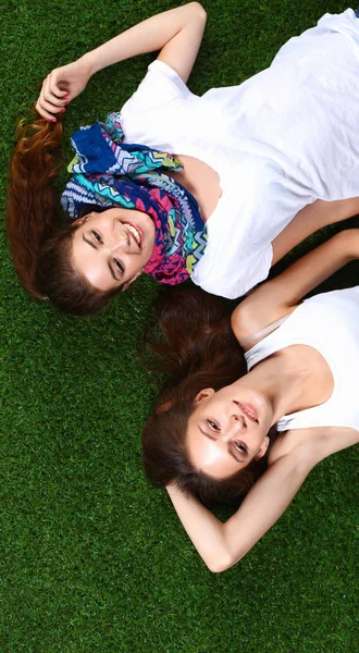 Two pretty girls lying on the fresh green grass — Stock Photo, Image