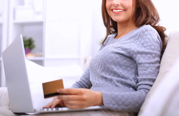 Belle femme souriante avec ordinateur portable et une carte de crédit — Photo
