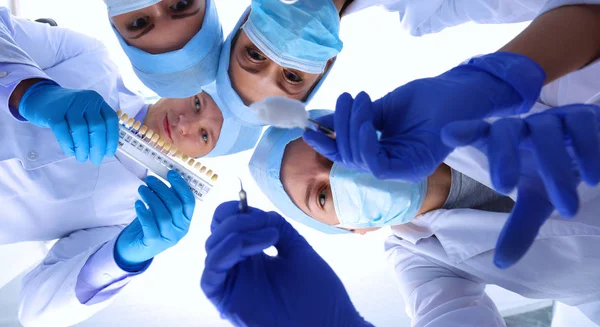 Squadra di chirurghi, donna con uniformi protettive, berretti e maschere — Foto Stock
