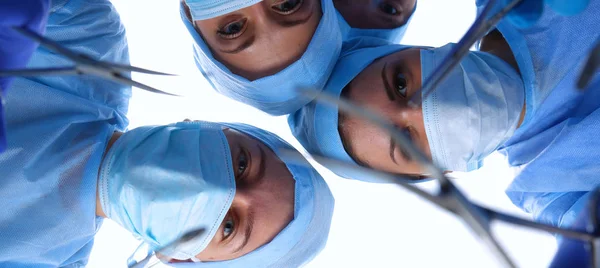 Equipe de cirurgiões, mulher vestindo uniformes protetores, bonés e máscaras — Fotografia de Stock