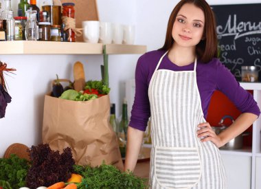 Onun mutfak masa alışveriş torbaları ile yakın duran genç kadın