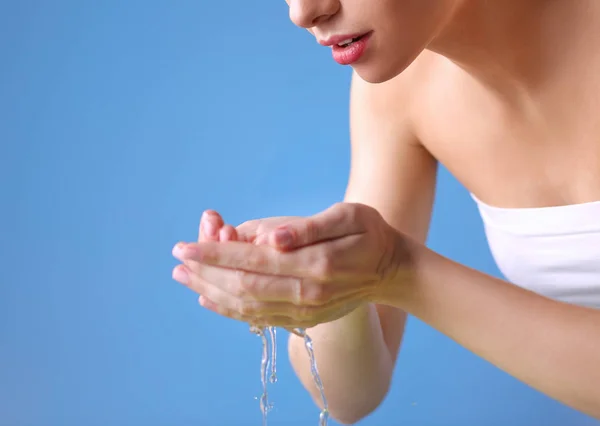Jonge vrouwelijke wassen van haar gezicht met helder water — Stockfoto