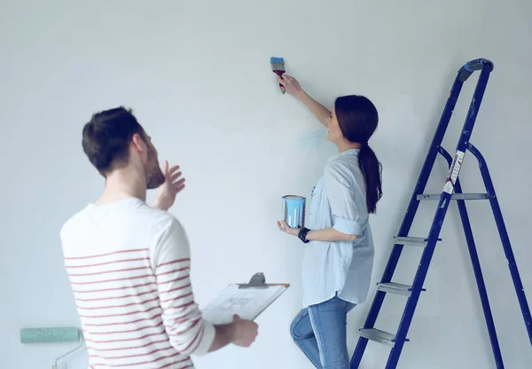 Portret van gelukkig lachend jong koppel schilderij interieur wand nieuw huis — Stockfoto