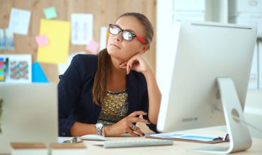 Moda tasarımcıları stüdyoda çalışıyor. Masanın üzerinde oturuyorlar.