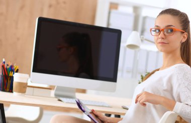 Moda tasarımcıları stüdyoda çalışıyor, masada oturuyorlar.