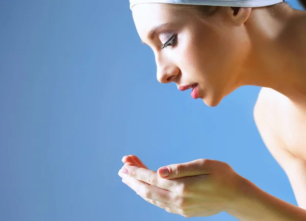 Young female washing her face with clear water