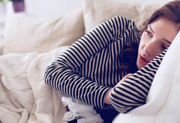 Portrait of a sick woman while sitting on the sofa — Stock Photo, Image