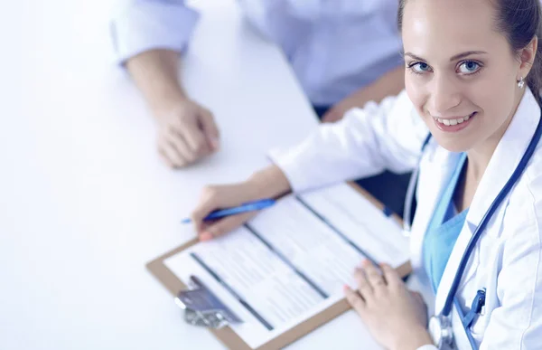 Doctor vrouw zitten met mannelijke patiënt aan de balie — Stockfoto