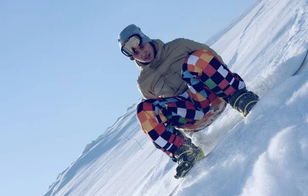 Сноубордист, сидящий на лыжном склоне — стоковое фото