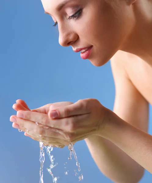 Mujer joven lavándose la cara con agua clara —  Fotos de Stock