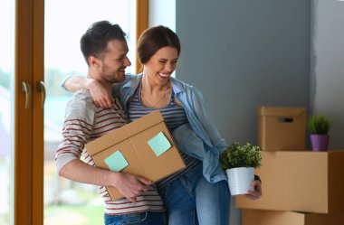 Mutlu genç çift açma veya kutu ambalaj ve yeni evine taşıdıktan