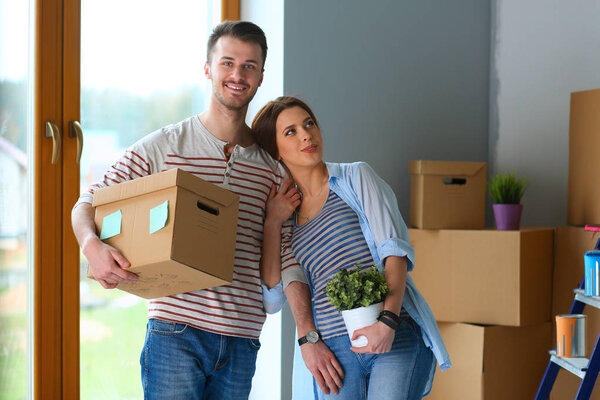 Happy young couple unpacking or packing boxes and moving into a new home