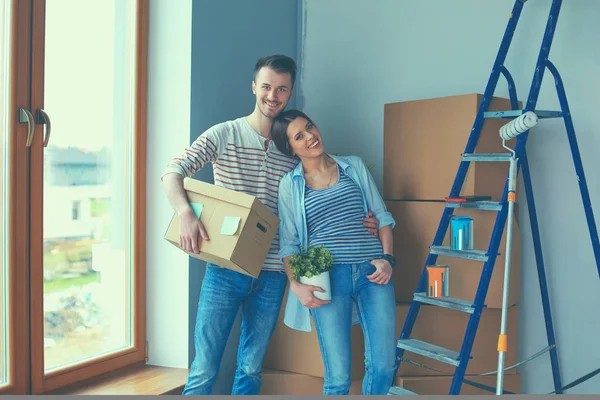 Glada unga par uppackning eller packa lådor och flyttar till ett nytt hem — Stockfoto