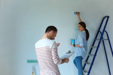 Mutlu gülümseyen genç çift boya iç cephe yeni ev portresi