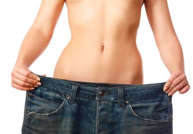 Woman showing how much weight she lost by wearing her old jeans clipart