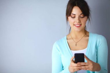Akıllı telefon kullanan ve okuyan bir kadın