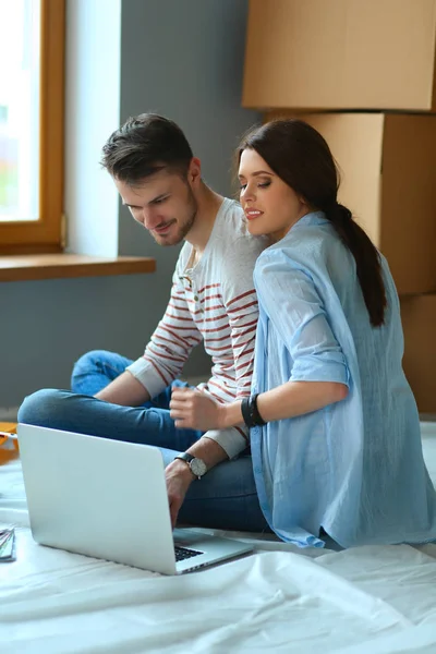 Jong koppel zittend op de vloer van hun nieuwe appartement — Stockfoto