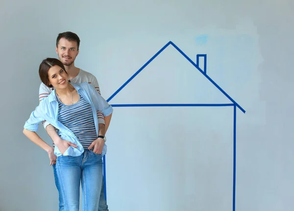 Couple sitting in front of painted home on wall — Stock Photo, Image