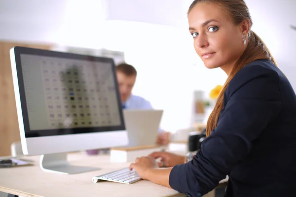 Jonge vrouw werkt in het kantoor, zit aan het bureau — Stockfoto