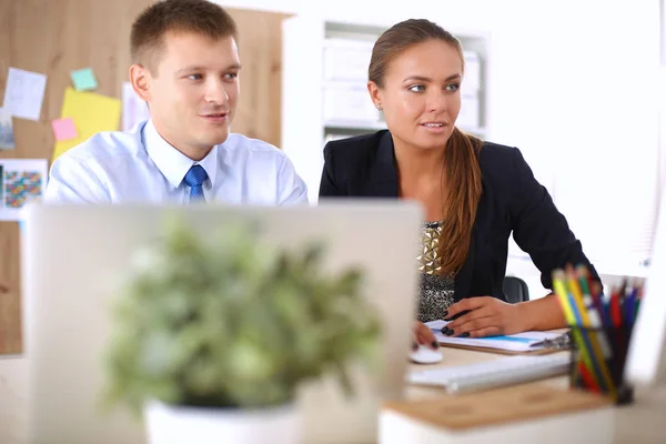 Fashion designers working in studio sitting on the desk — Stock Photo, Image