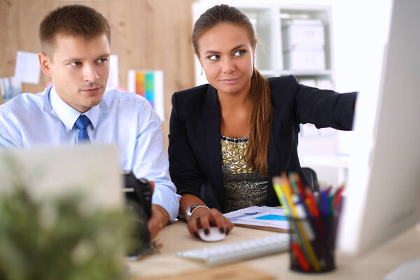 Модные дизайнеры, работающие в студии сидя на столе