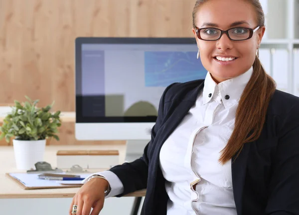 Jonge vrouw werkt in het kantoor, zit aan het bureau — Stockfoto