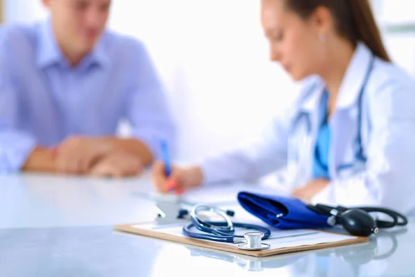 Doctora sentada con paciente masculino en el escritorio — Foto de Stock