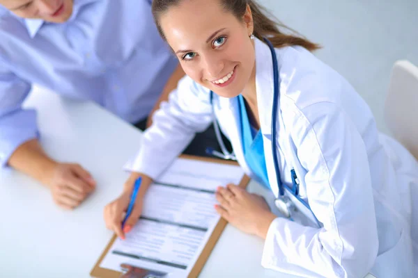 Doctora sentada con paciente masculino en el escritorio —  Fotos de Stock